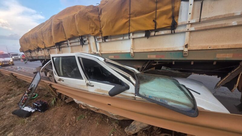 Carro fica espremido embaixo de  caminhão e ocupantes saem ilesos